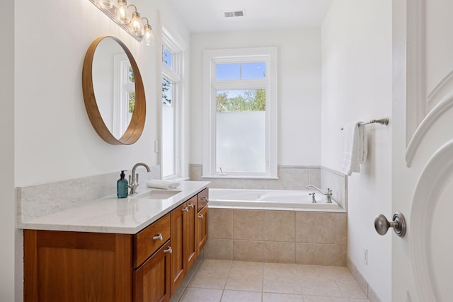 full bathroom with tile patterned flooring, visible vents, a garden tub, and vanity
