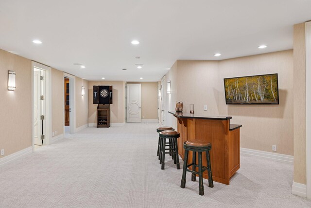 bar featuring recessed lighting, light colored carpet, and a bar