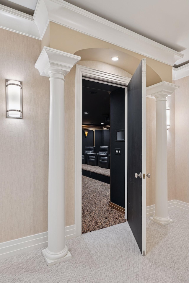 corridor featuring crown molding, carpet flooring, decorative columns, and baseboards