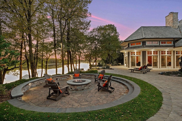 view of patio with a water view and a fire pit
