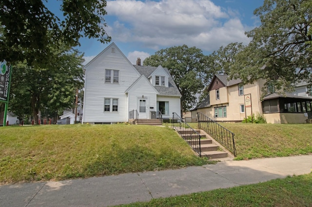 view of front facade featuring a chimney and a front yard