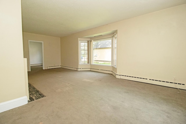 carpeted empty room featuring baseboard heating and baseboards