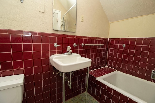 full bathroom featuring toilet, tile walls, tiled shower, and vaulted ceiling
