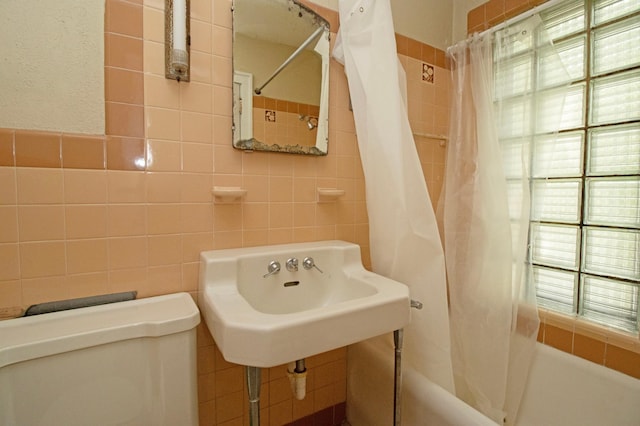 bathroom featuring a wealth of natural light and tile walls