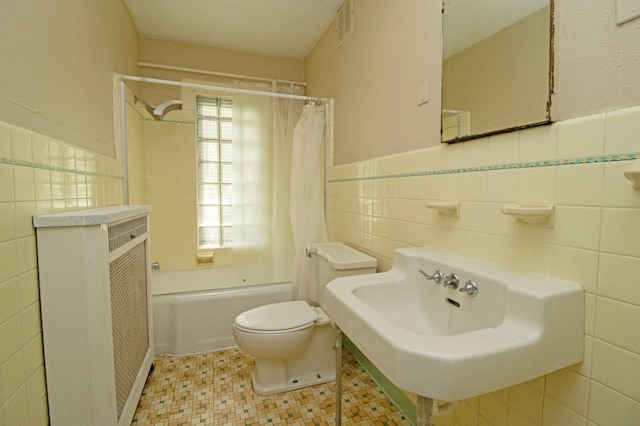 bathroom featuring visible vents, toilet, wainscoting, tile walls, and shower / bath combo with shower curtain