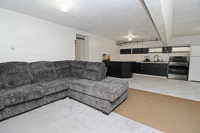 living room with a textured ceiling and concrete block wall