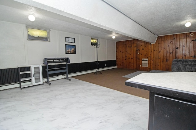 interior space with wood walls, a textured ceiling, and heating unit