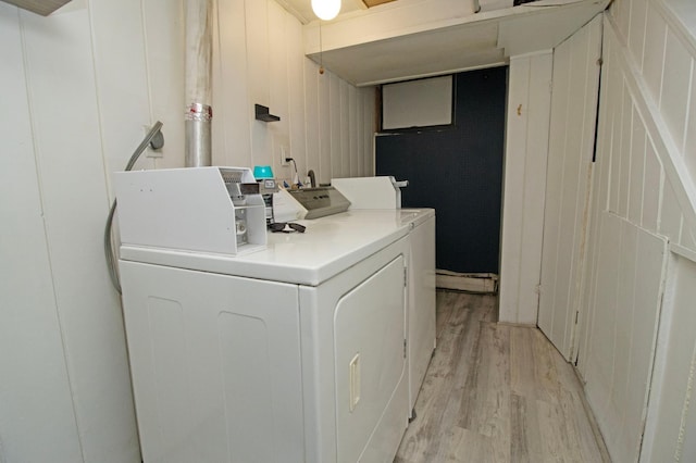 common laundry area with washing machine and clothes dryer and light wood-type flooring