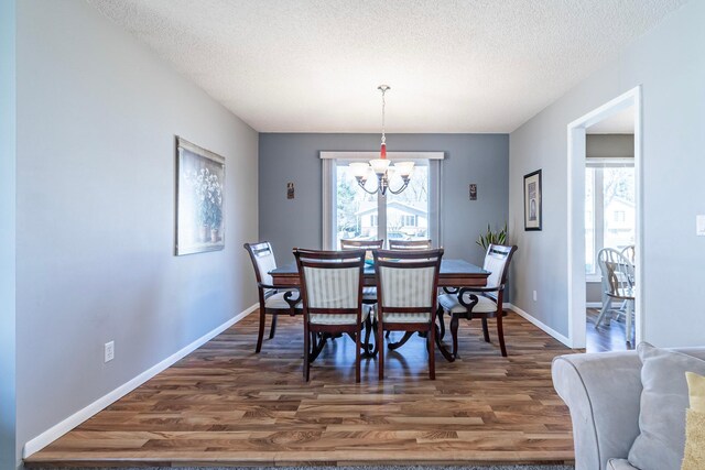 dining room featuring a wealth of natural light, an inviting chandelier, and wood finished floors