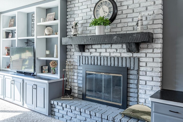 interior details featuring built in features, carpet flooring, and a brick fireplace