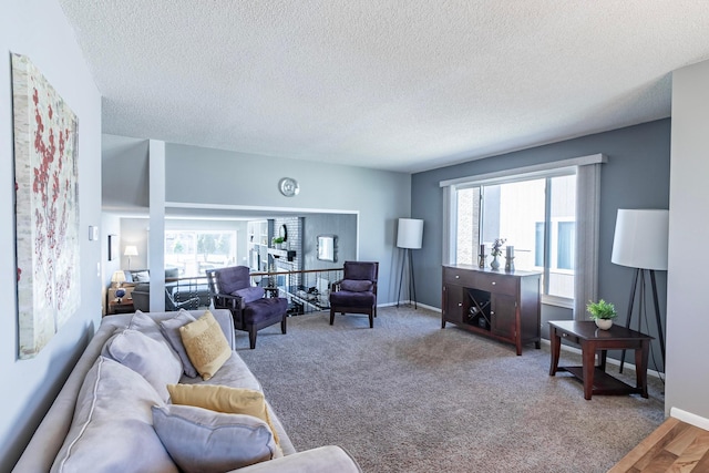 living area featuring plenty of natural light, a textured ceiling, and baseboards