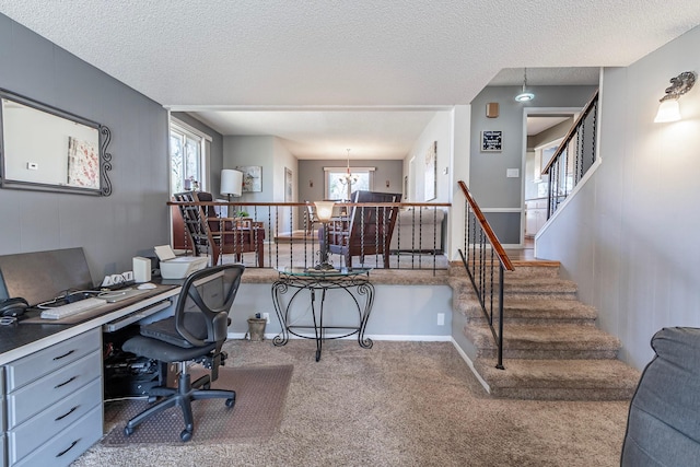 office area featuring a healthy amount of sunlight, a textured ceiling, an inviting chandelier, and carpet floors