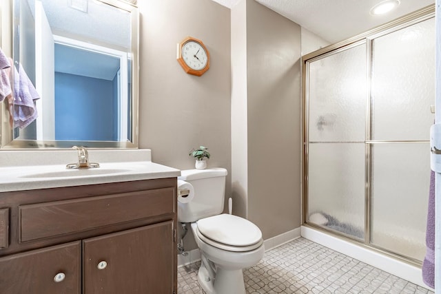 bathroom with a shower stall, vanity, baseboards, and toilet