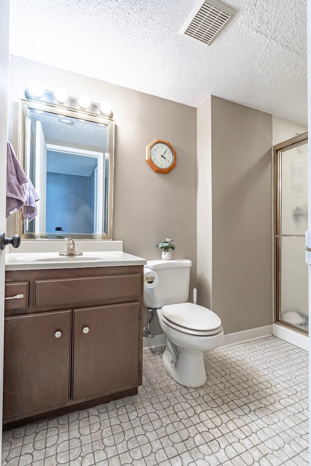 bathroom with vanity, a stall shower, a textured ceiling, toilet, and visible vents