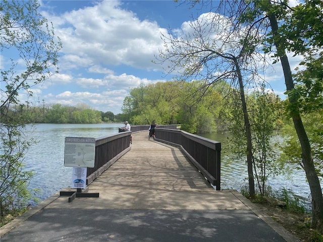 dock area with a water view and a view of trees