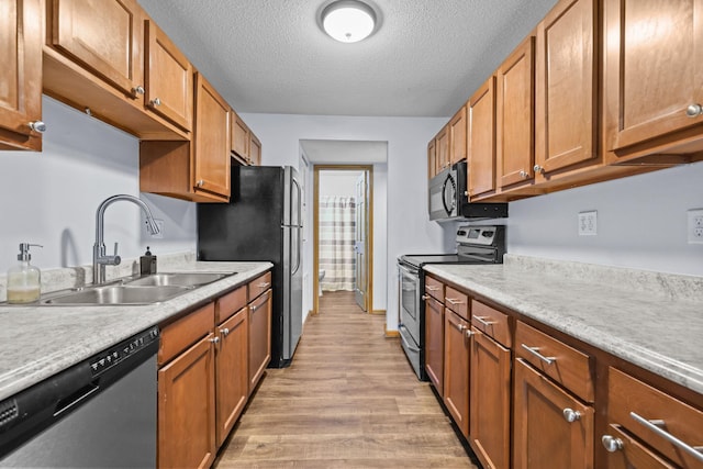 120 Demont Ave E Unit 103, Little Canada, MN 55117 - kitchen featuring appliances with stainless steel finishes, light wood-style floors, light countertops, a textured ceiling, and brown cabinets
