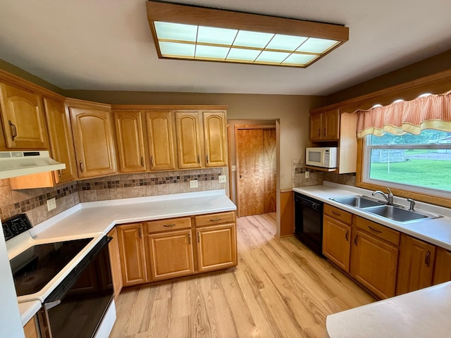603 Maple Ave, Olivia, MN 56277 - kitchen with under cabinet range hood, electric range, white microwave, black dishwasher, and light wood-style floors