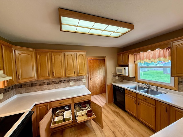 603 Maple Ave, Olivia, MN 56277 - kitchen featuring white microwave, black dishwasher, light wood-style floors, tasteful backsplash, and light countertops