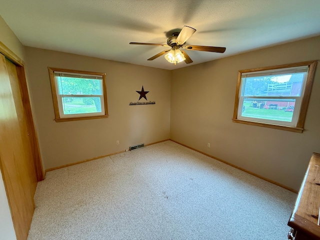 603 Maple Ave, Olivia, MN 56277 - carpeted empty room with healthy amount of natural light and ceiling fan