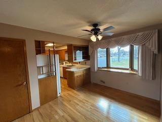 kitchen featuring light countertops, brown cabinets, a ceiling fan, and light wood finished floors