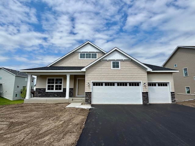 548 Mallard St NE, Hanover, MN 55341 - craftsman-style house with stone siding, asphalt driveway, covered porch, and an attached garage