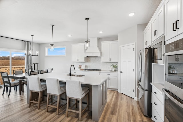 548 Mallard St NE, Hanover, MN 55341 - kitchen featuring custom exhaust hood, appliances with stainless steel finishes, decorative backsplash, light wood-style flooring, and recessed lighting