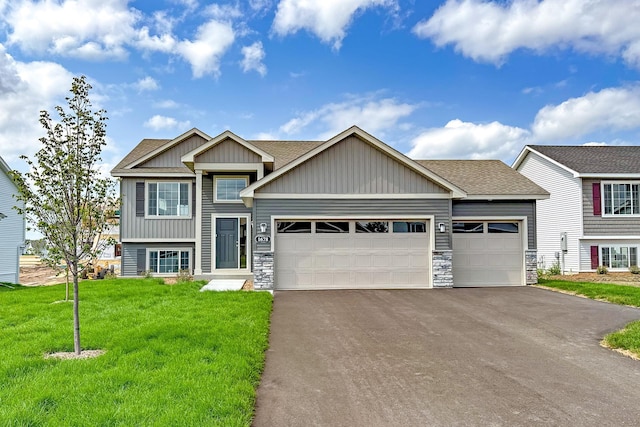 view of front facade with stone siding, an attached garage, board and batten siding, a front yard, and aphalt driveway