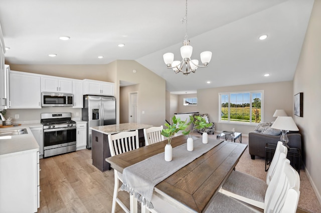 dining space featuring a chandelier, lofted ceiling, light wood finished floors, and recessed lighting