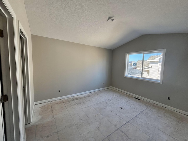 unfurnished bedroom featuring lofted ceiling, baseboards, visible vents, and a textured ceiling