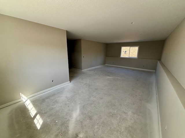 empty room featuring baseboards and concrete flooring