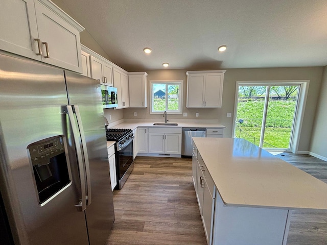 579 Mallard St NE, Hanover, MN 55341 - kitchen featuring stainless steel appliances, a sink, dark wood-type flooring, a center island, and white cabinets