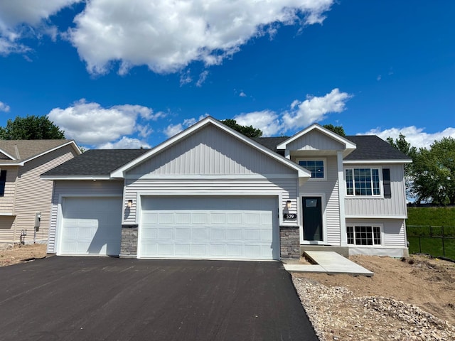 579 Mallard St NE, Hanover, MN 55341 - view of front of property with driveway, an attached garage, and stone siding