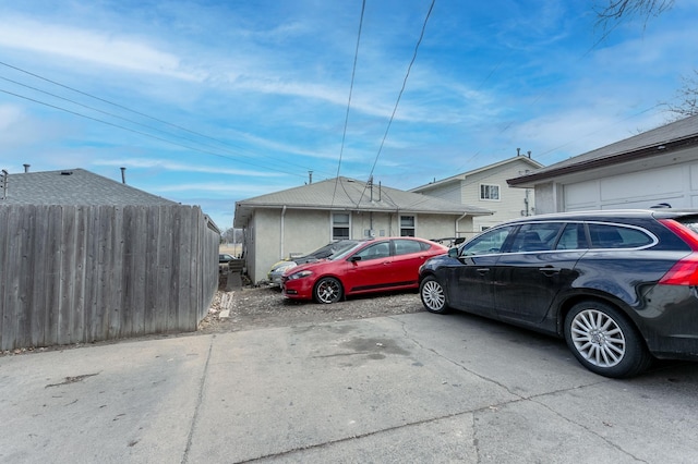 view of parking / parking lot featuring fence