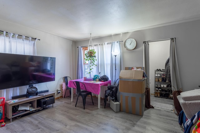 dining space with wood finished floors and ornamental molding