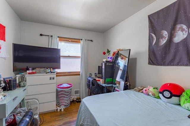 bedroom featuring wood finished floors and visible vents