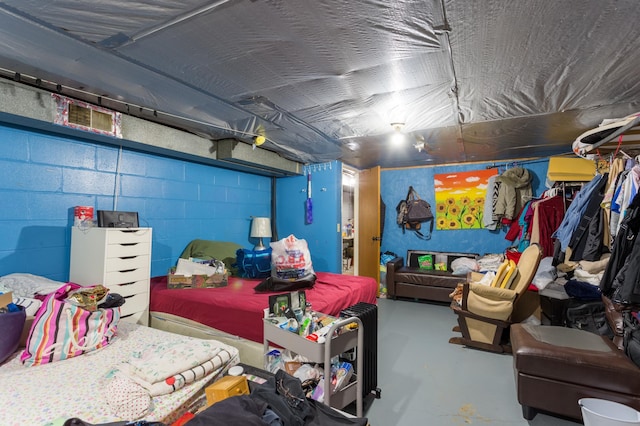 bedroom featuring concrete floors and concrete block wall