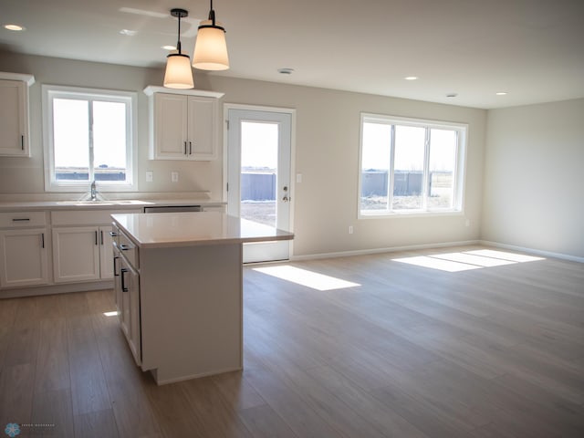 861 2nd Ave, Horace, ND 58047 - kitchen featuring a kitchen island, light wood-style floors, a sink, light countertops, and open floor plan