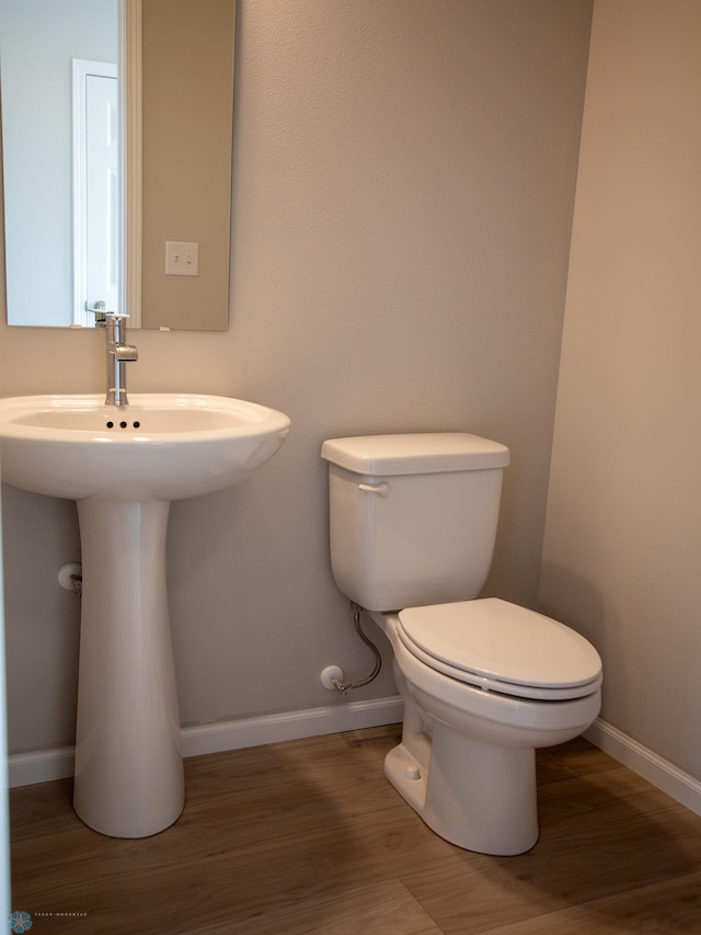 861 2nd Ave, Horace, ND 58047 - bathroom with baseboards, toilet, wood finished floors, and a sink