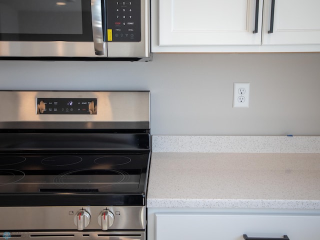 861 2nd Ave, Horace, ND 58047 - detailed view of appliances with stainless steel finishes, white cabinets, and light stone countertops