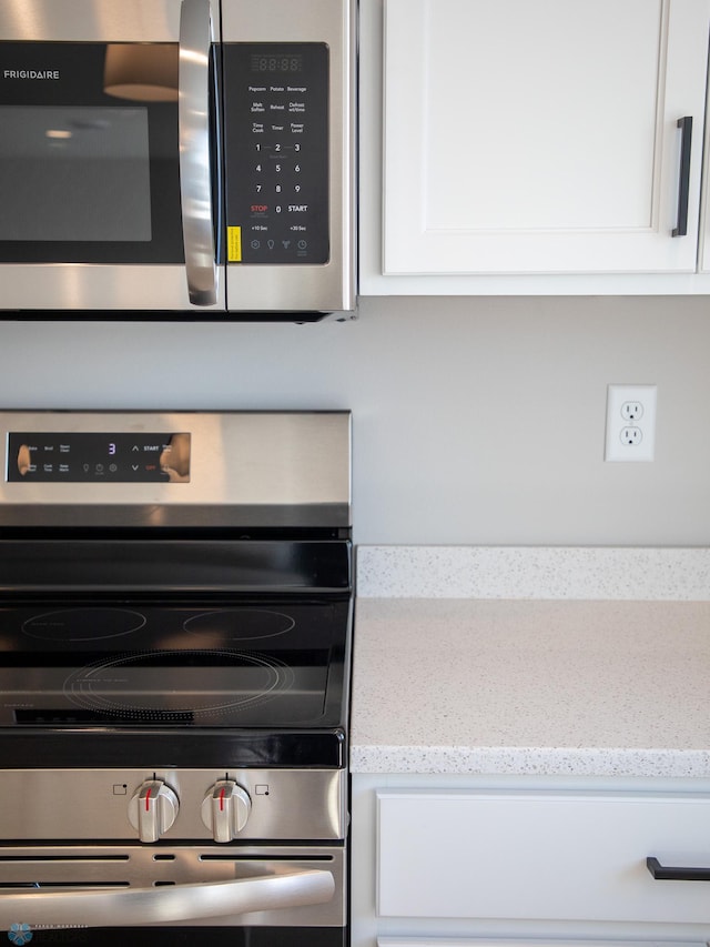 861 2nd Ave, Horace, ND 58047 - kitchen view of stainless steel appliances, white cabinets, and light stone counters