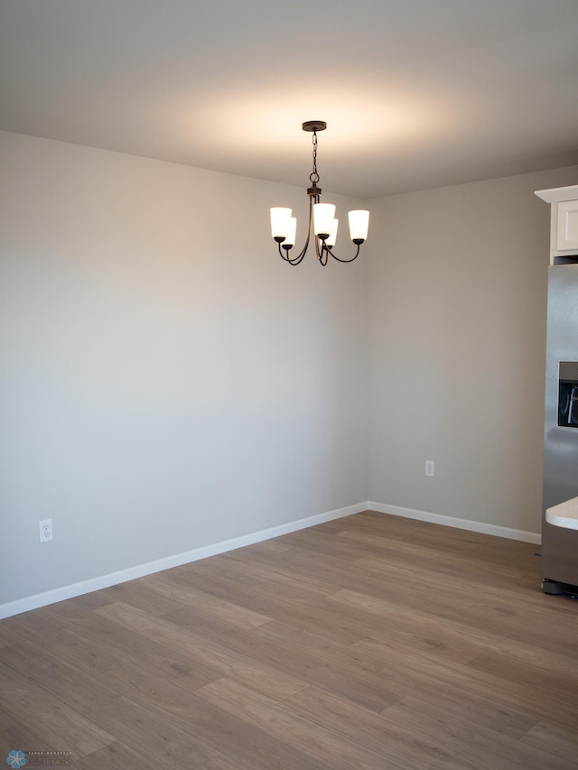 861 2nd Ave, Horace, ND 58047 - spare room featuring a chandelier, wood finished floors, and baseboards