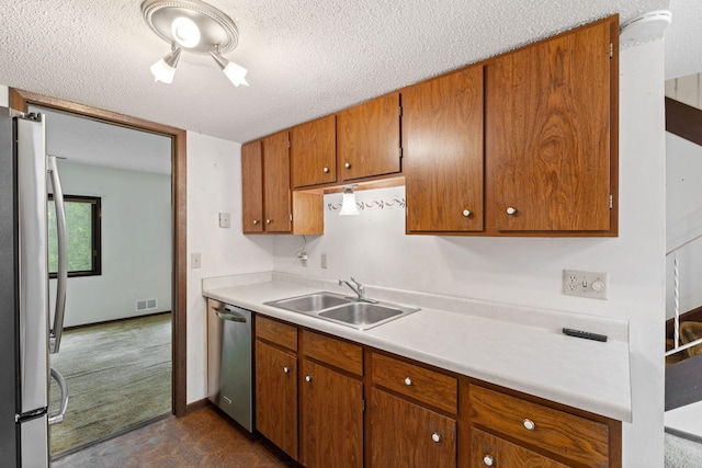 7508 Germane Trl Unit 0, Apple Valley, MN 55124 - kitchen featuring a sink, appliances with stainless steel finishes, brown cabinetry, light countertops, and a textured ceiling