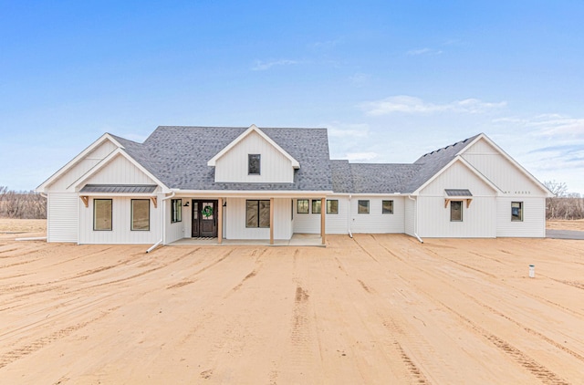 modern farmhouse style home featuring roof with shingles and board and batten siding