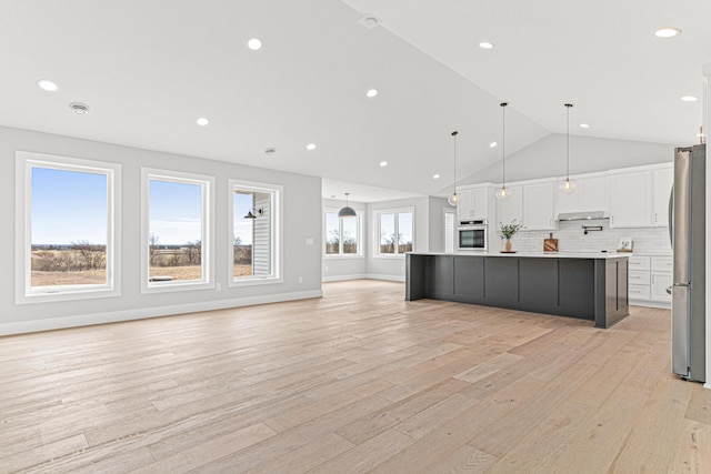 kitchen featuring open floor plan, light wood-style flooring, white cabinetry, light countertops, and stainless steel appliances