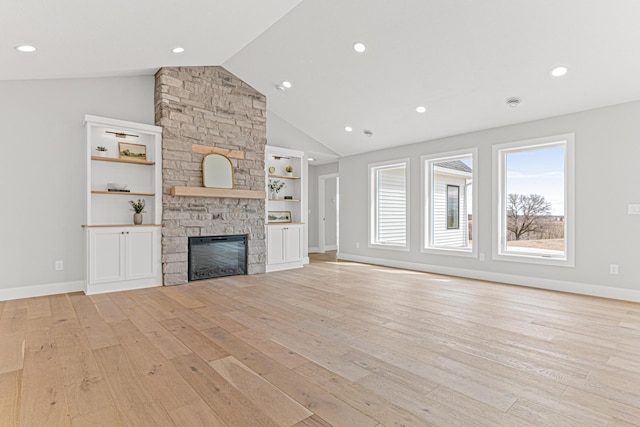 unfurnished living room with light wood-style flooring, a stone fireplace, vaulted ceiling, recessed lighting, and baseboards