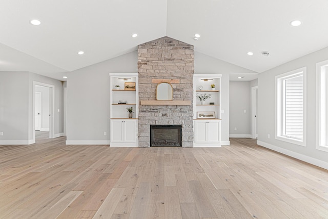 unfurnished living room with a stone fireplace, light wood-type flooring, vaulted ceiling, and baseboards