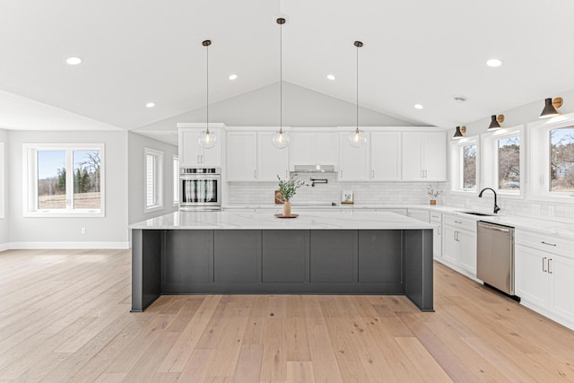 kitchen featuring stainless steel appliances, a wealth of natural light, white cabinetry, and lofted ceiling