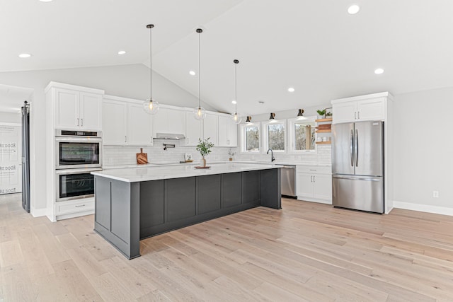kitchen with stainless steel appliances, white cabinets, a sink, and backsplash