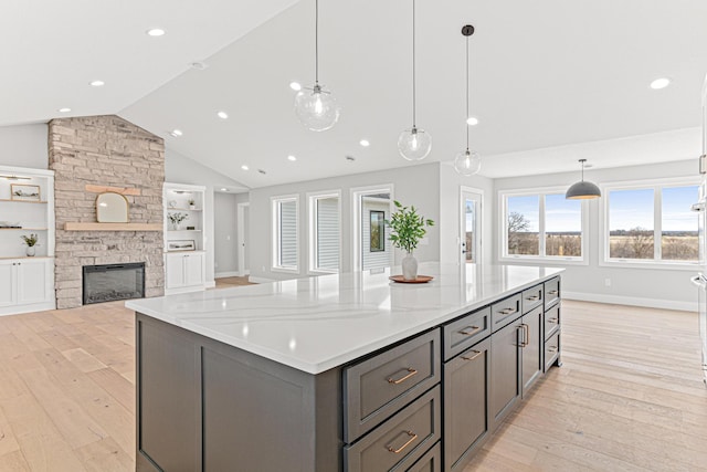 kitchen with light wood-type flooring, a large island, gray cabinetry, and vaulted ceiling