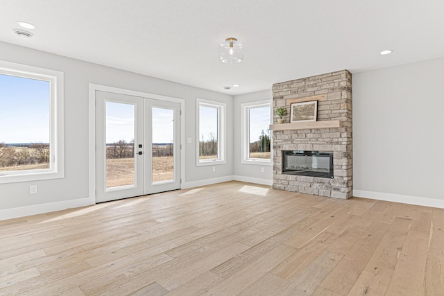 unfurnished living room featuring french doors, baseboards, and light wood-style floors